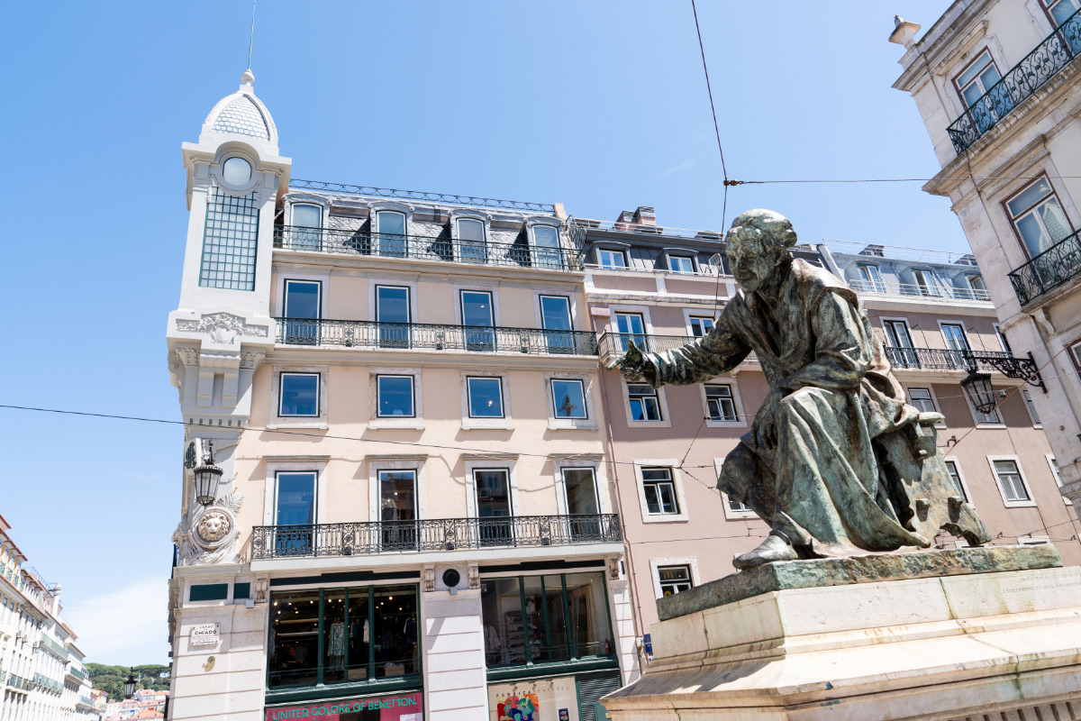 Estátua em homenagem ao poeta António Ribeiro Chiado no Largo do Chiado, com o edifício da Benetton ao fundo