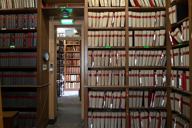 uma sala do arquivo municipal de lisboa, com as paredes forradas de estantes com livros antigos