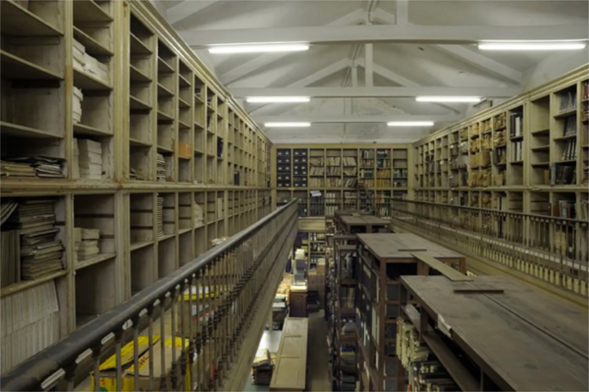 Fotografia do interior do Arquivo - dois pisos repletos de estantes de livros e documentos