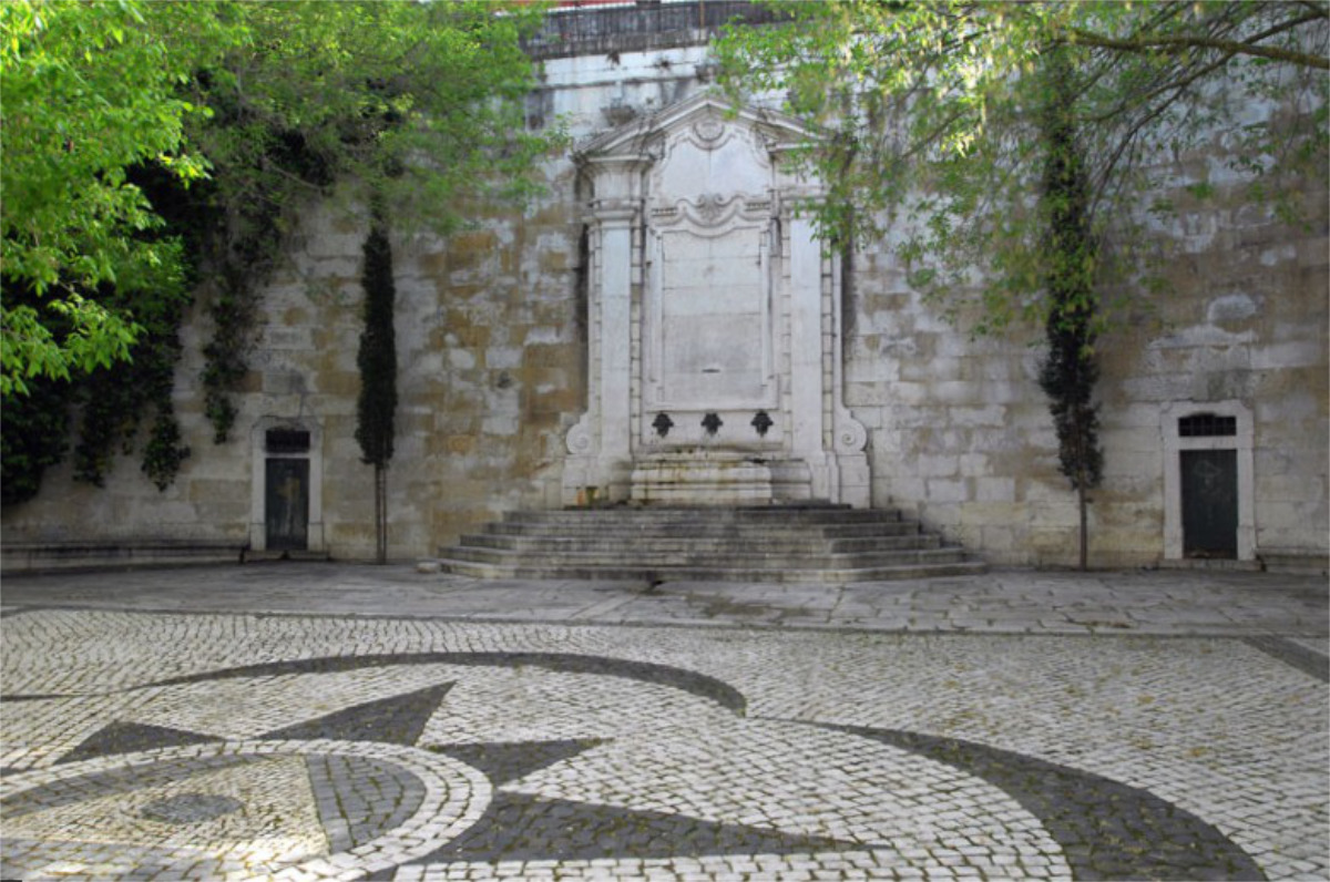 Chafariz implantado num amplo largo, com calçada tradicional portuguesa, criado propositadamente para o enquadrar, composto por muro em cantaria, parcialmente em perfil curvo.