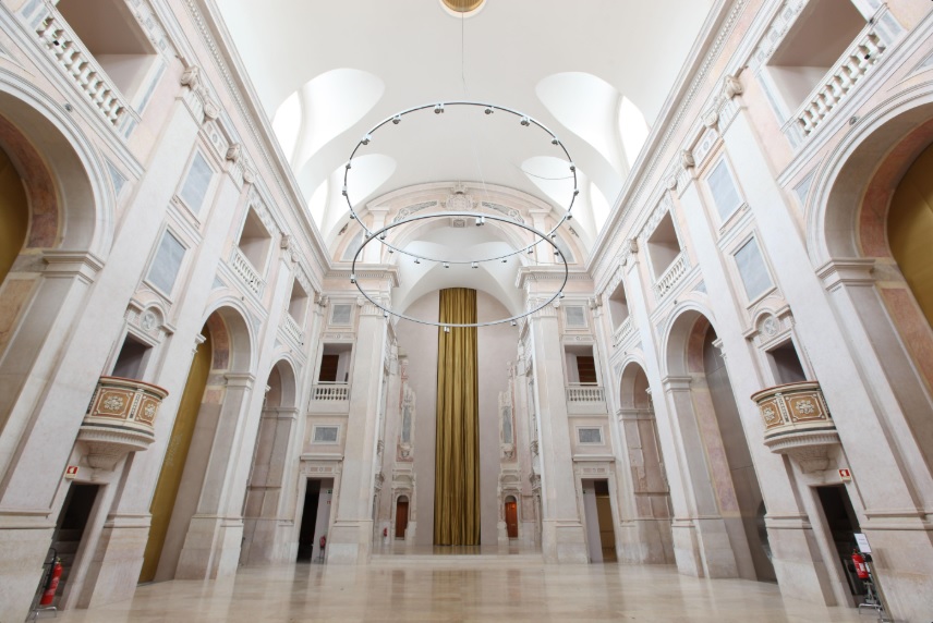 Nave da antiga Igreja de São Julião com detalhes em mármore, arcos e iluminação moderna.