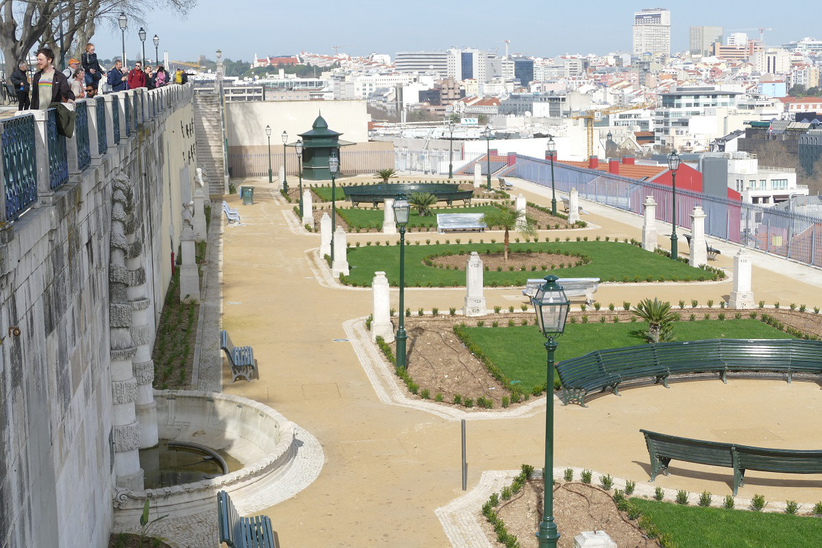 Um grande parque com bancos, localizado no Jardim São Pedro de Alcântara, rodeado por árvores e áreas verdes.